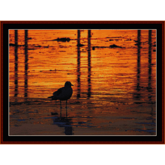 Counted Cross Stitch Pattern by Cross Stitch Collectibles of a bird on water at sunset with orange and red hues