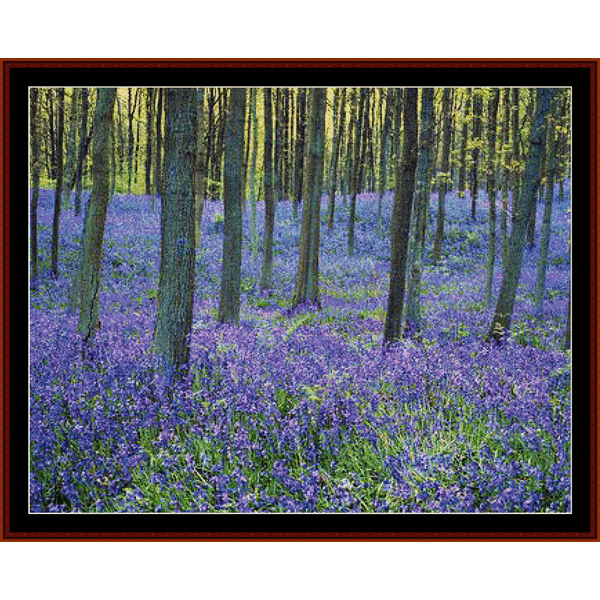 Cross Stitch Pattern by Cross Stitch Collectibles depicting a forest floor covered with bluebell flowers, surrounded by trees.