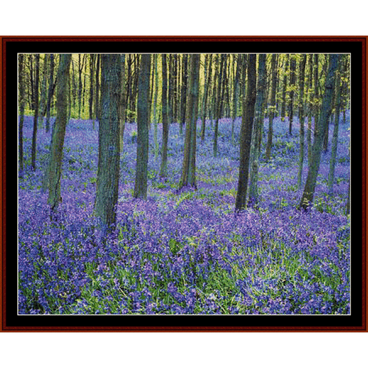 Cross Stitch Pattern by Cross Stitch Collectibles depicting a forest floor covered with bluebell flowers, surrounded by trees.