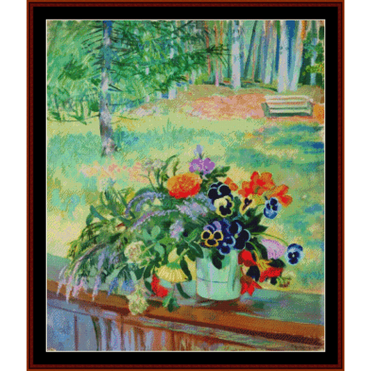 Counted Cross Stitch Pattern by Cross Stitch Collectibles depicting a bouquet of flowers arranged on a balcony, with a mix of colorful flowers in a white vase, set against a blurred background of a garden or park setting.