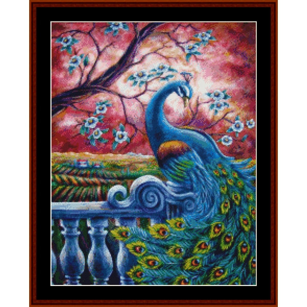 Counted Cross Stitch Pattern - Proud Peacock, Fantasy - Cross Stitch Collectibles - A framed decorative artwork showing a blue peacock with a bright multicolored tail beside a white balustrade, under a pink and red sky with blossoming branches.