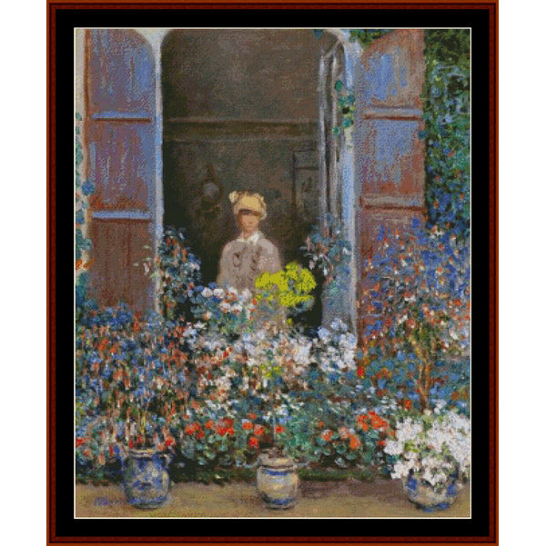Counted Cross Stitch Pattern by Cross Stitch Collectiblesof a woman standing behind a floral arrangement with a garden view.