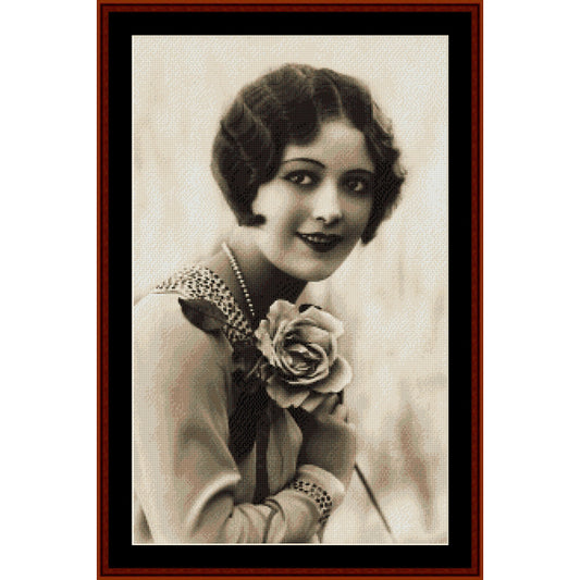 Vintage-style portrait Counted Cross Stitch Pattern by Cross Stitch Collectibles of a woman holding a rose, framed in brown.