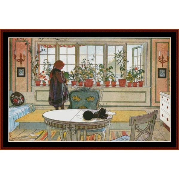 Colorful Counted Cross Stitch Pattern by Cross Stitch Collectibles of a room with a person standing by a window filled with potted plants.