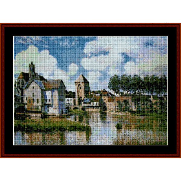 Counted Cross Stitch Pattern: Moret Sur Loing - Alfred Sisley- Cross Stitch Collectibles.  A framed cross-stitch or needlework artwork depicting a scenic village with church towers, trees, and a river under a cloudy blue sky, shown with a dark red-brown frame and black matting.