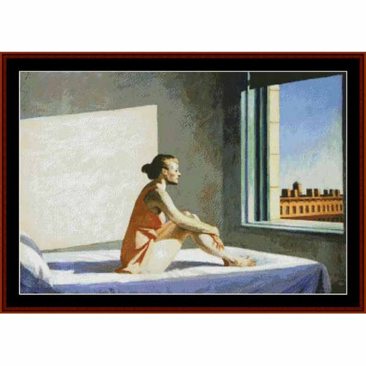 Counted Cross Stitch Pattern: Morning Sun by Edward Hopper - Cross Stitch Collectibles - A framed art print depicting a woman sitting on a bed in a room, looking out a window at a city building under a blue sky. The artwork is presented with a dark red-brown frame and white matting.