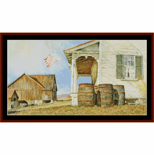 Counted Cross Stitch Pattern: Mountain Air, Americana - Cross Stitch Collectibles - A framed landscape painting depicting a rustic farm scene with a white house, wooden barrels, a weathered barn, an American flag, and dry grass under a pale blue sky.
