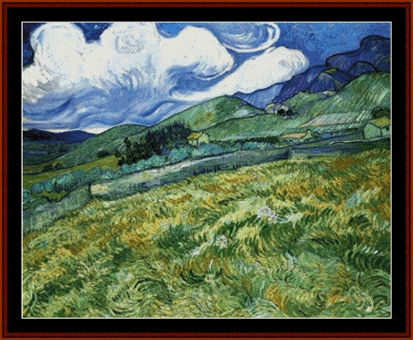 Counted Cross Stitch Pattern: Mountainous Landscape by Vincent Van Gogh - Cross Stitch Collectibles - A framed landscape art print depicting a swirling blue sky, green hills, and a yellow-green field in a Van Gogh-inspired post-impressionist style, enclosed in a dark red border.