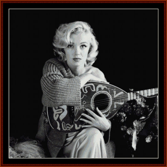 Counted Cross Stitch Pattern: Musical Marilyn Monroe - Cross Stitch Collectibles - Black and white portrait of a woman holding a decorative lute-like stringed instrument, framed by a dark border with a red inner frame.