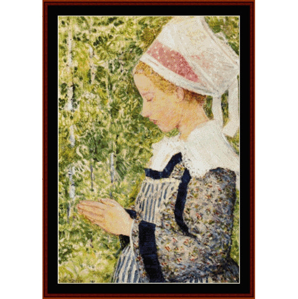 Counted Cross Stitch Pattern: Peasant Girl Praying by Frederick Childe-Hassam - Cross Stitch Collectibles - A framed art print depicting a woman in profile wearing a white bonnet with pink trim and a blue-and-white patterned dress, set against a background of green foliage. 