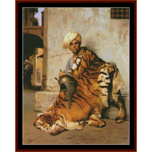 Counted Cross Stitch Pattern: Pelt Merchant of Cairo by J. L. Gerome - Cross Stitch Collectibles - A framed painting depicting a man in a white turban seated on a tiger, with another tiger lying beside him, set against a textured beige wall in an architectural scene.