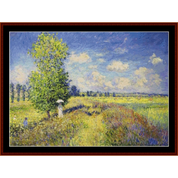 Counted Cross Stitch Pattern: Poppy Field by Claude Monet - Cross Stitch Collectibles - Impressionist landscape oil painting in a dark brown wooden frame, depicting a sunlit green tree, grassy field, and blue sky with white clouds.