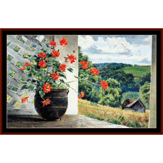 Counted Cross Stitch Pattern: Potted, Americana - Cross Stitch Collectibles - A framed landscape painting depicting a potted plant with bright red flowers on a porch, overlooking a green countryside scene with rolling hills, trees, and a small cabin under a cloudy sky.