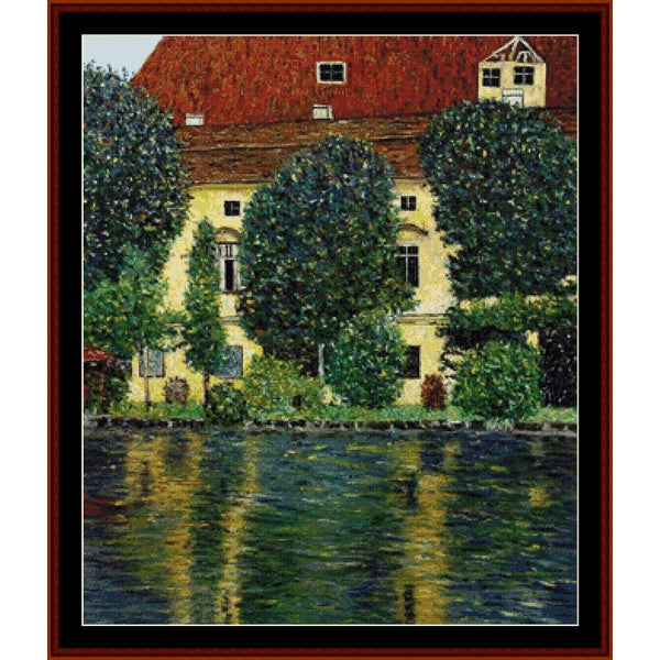 Counted Cross Stitch Pattern – Schloss Kammer on the Attersee by Gustav Klimt - Cross Stitch Collectibles - A framed art print depicting a yellow building with a red roof, surrounded by green trees and bushes, with reflections in a dark body of water.